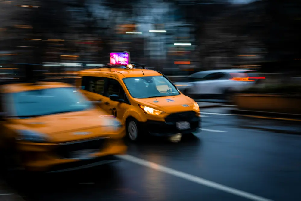 Yellow taxis driving on a wet city street