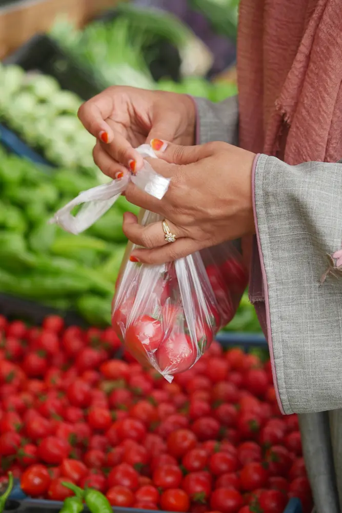 Woman choosing fresh vegetables at a market stall